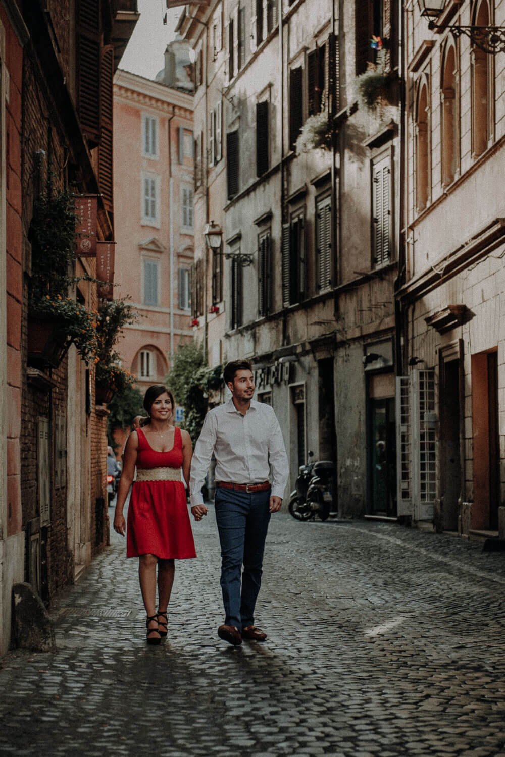 engaged couple walking in historic center of rome, engagement photographer in rome