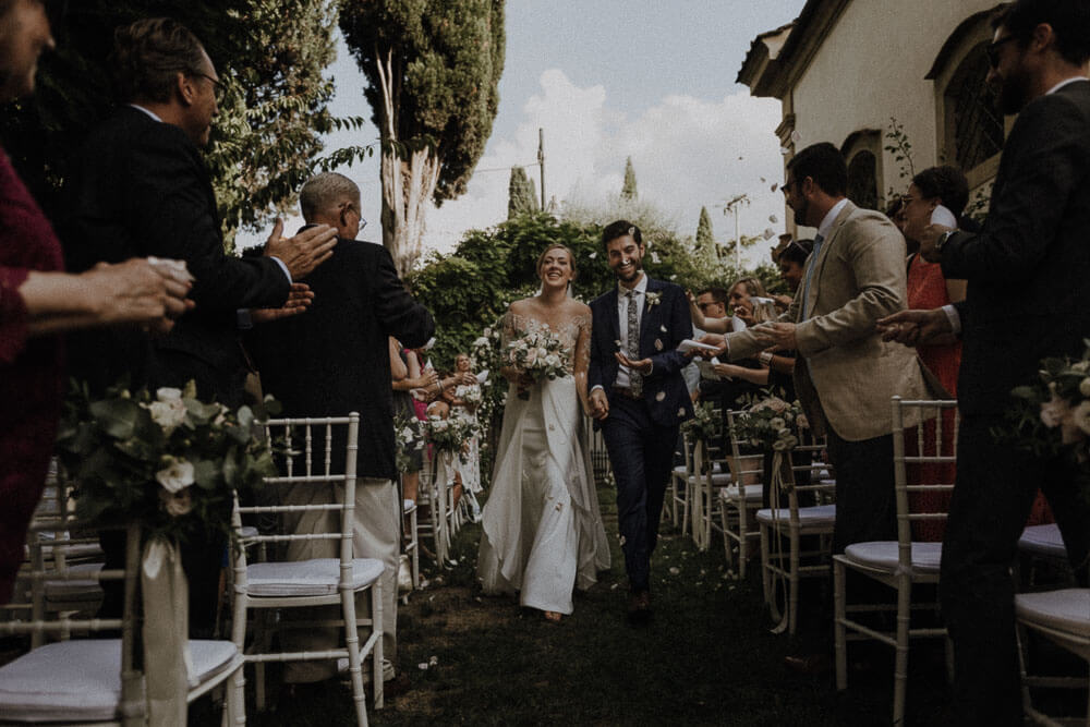 newlyweds walking in the aisle with launch of confetti, florence wedding