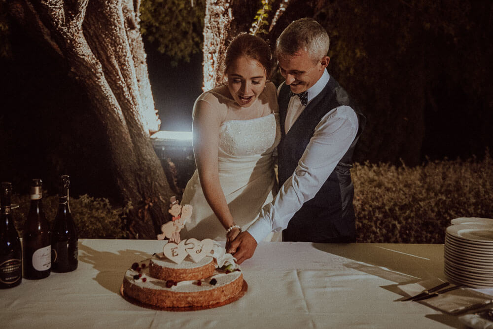 wedding in monteriggioni, tuscany: bride and groom cutting the cake