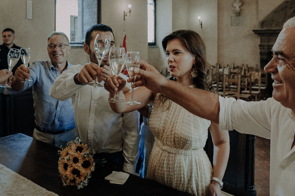 married couple in the town hall of cortona are having a toast