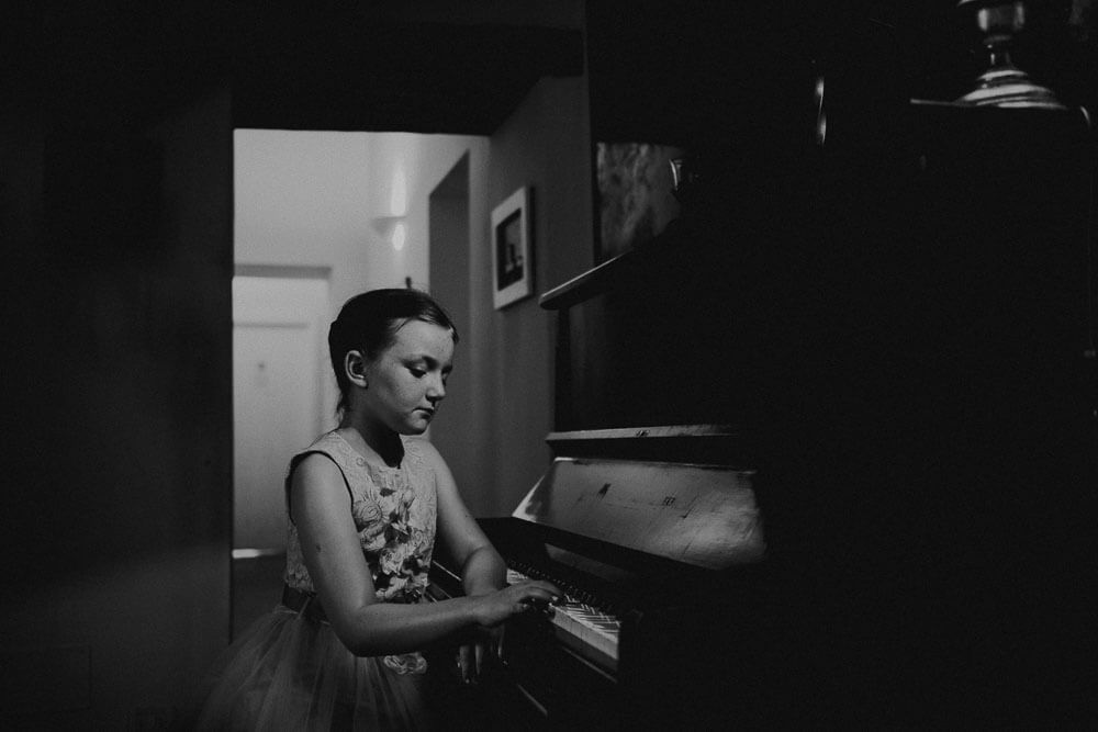 wedding in tuscany: flower girl playing piano